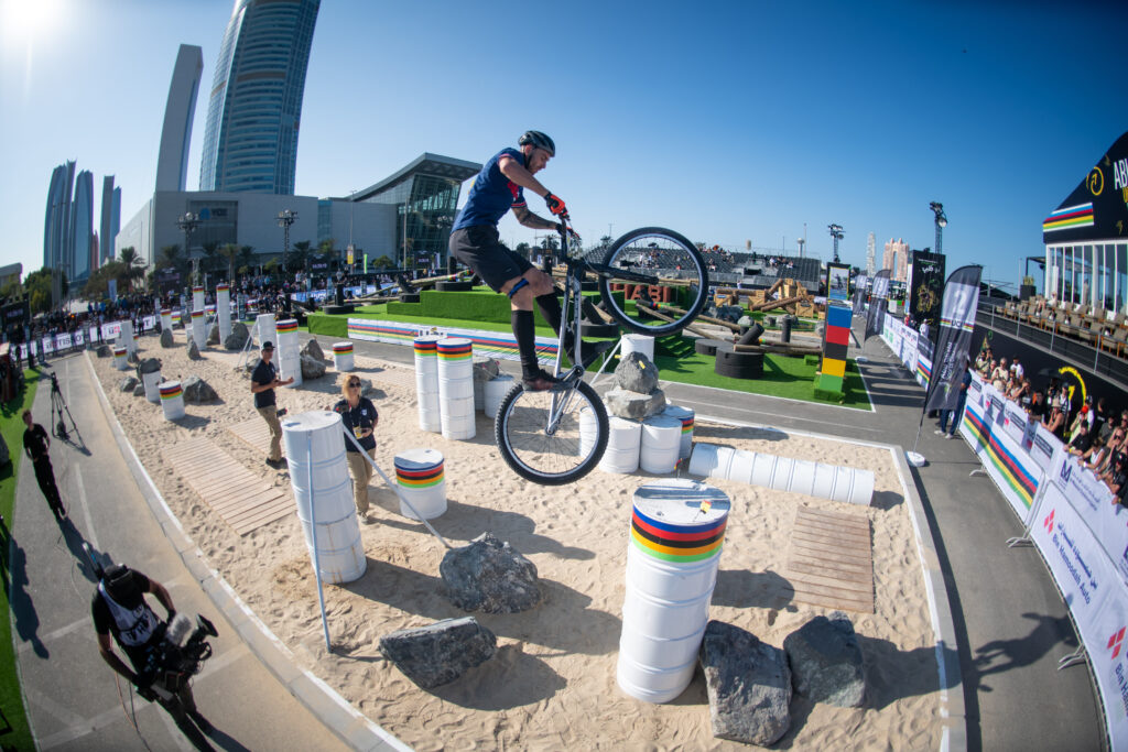 Cycliste effectuant un saut en vtt trial lors d'une compétition.