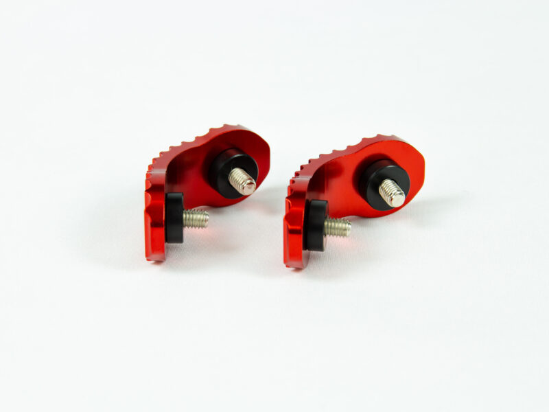 sabot waw 2 pieces + vis + spacers Deux fixations rouges en métal sur fond blanc.