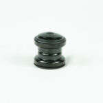 Pièce cylindrique noire sur fond blanc.