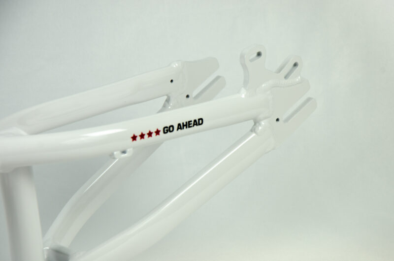 Cadre de vélo blanc avec logo 'Go Ahead'.