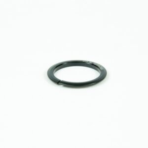 Anneau métallique noir sur fond blanc.