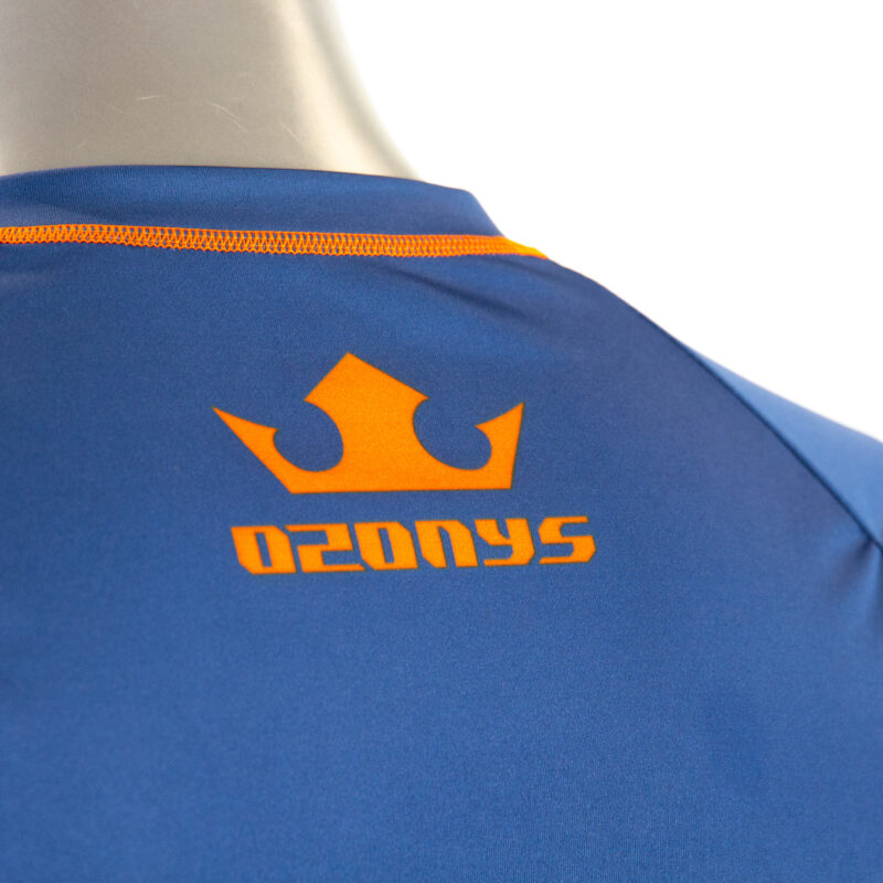 Détail du logo orange sur maillot bleu.