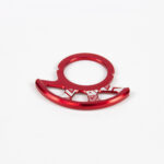 Anneau rouge métallique sur fond blanc.