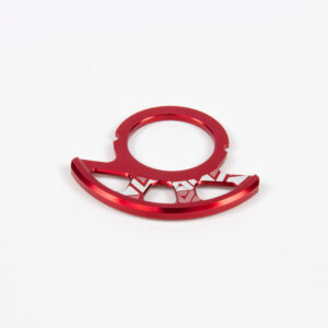 Anneau rouge métallique sur fond blanc.