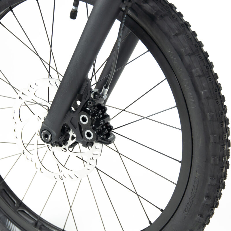 Gros plan roue et frein à disque vélo noir.